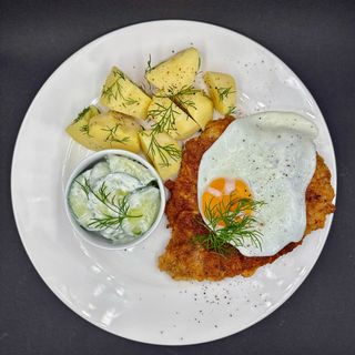 Kotlet schabowy z jajkiem sadzonym, z gotowanymi ziemniakami i mizerią