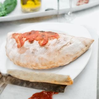 Calzone al forno con pomodoro, mozzarella e prosciutto cotto