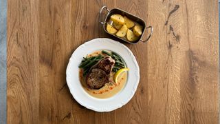 Свинний стейк на кості з соусом, спаржевою квасолею та печеною картоплею (600г)