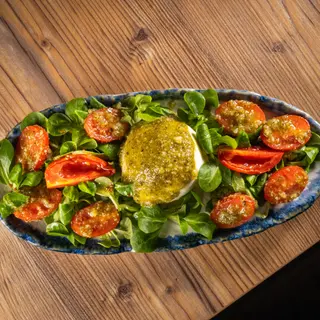 Burrata amb variat de tomàquets al pesto i canonges