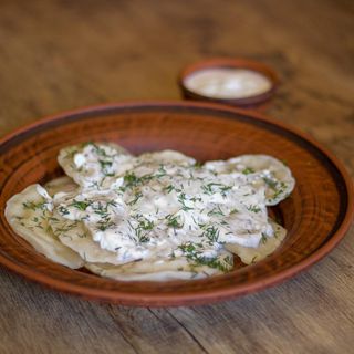 Вареники з картоплею та соусом з сметани, зелені та часника (270г/10шт)