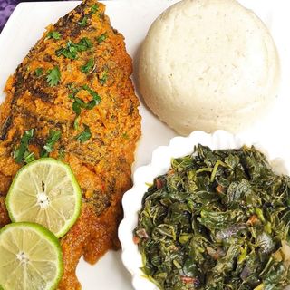 Tilapia in coconut sauce served with semolina and traditional vegetables