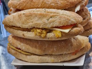 Bocadillo de tortilla de papas con tomate, queso con mayonesa