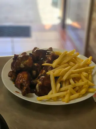 Jamoncitos de pollo fritos, papas fritas y salsa de barbacoa