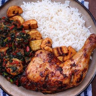 White rice served with chicken, plantains and eforiro vegetable sauce