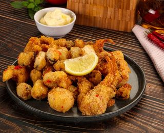 Fritto misto din fructe de mare si cartofi prajiti servite cu sos aioli