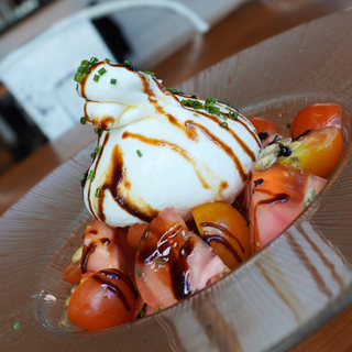 Burrata de leche de oveja, selección de tomates y pipas garrapiñadas.