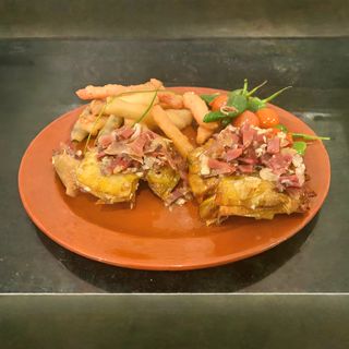 Flor de alcachofa confitada con salteado de jamón ibérico