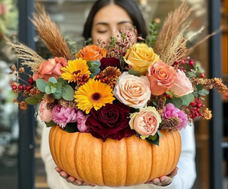 Aranjament floral în dovleac cu trandafiri, gerbera și flori de sezon