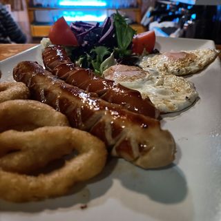 Salchichas con 2 huevos, ensalada y aros de cebolla
