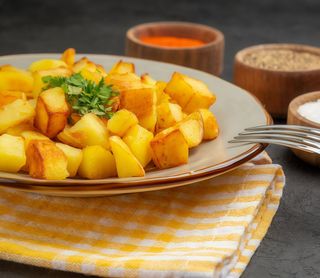 Patatas fritas pequeñas con alioli y bravas
