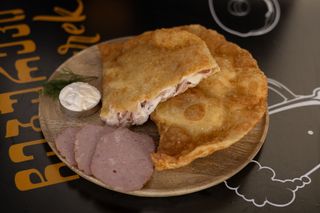 Cheburek with ham and cheese and garlic sauce.