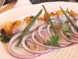 Оселедець з маринованою цибулькою на запеченій картопельці