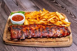 Tambal de porc servite cu cartofi prajiti si sos bbq