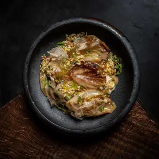 Cebollas asadas y aliñadas con tamarindo, cremoso de dashi, furikake y cebolleta china