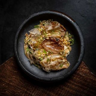 Cebollas asadas y aliñadas con tamarindo, cremoso de dashi, furikake y cebolleta china