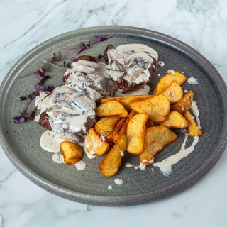 Медальоны под грибным соусом с картофельными дольками.