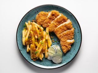 Курячий шніцель з картоплею фрі та сирним соусом