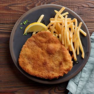 Cotoletta di petto di pollo panata e fritta tagliata a mano con chips