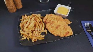 Șnițel de pui cu cartofi prăjiți și sos cheddar
