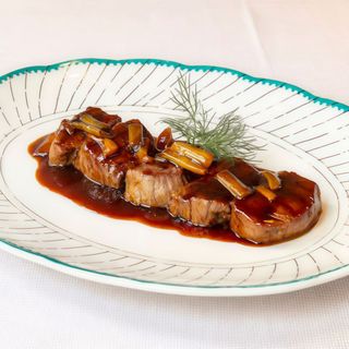 Daditos de carne roja en su jugo a la sartén con piparras