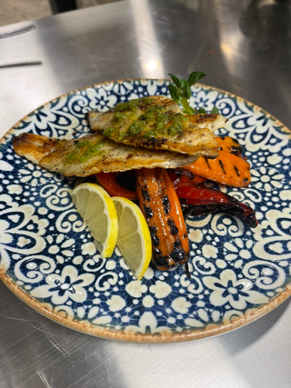 Филе от лаврак на плоча със сос чимичури и гриловани зеленчуци (330г)