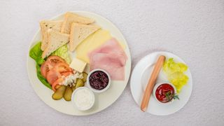 Zestaw śniadaniowy (pieczywo, masło, ogórek świeży, pomidor, cebulka, wędlina, ser, twaróg, dżem, parówka z wody z ketchupem i musztardą)