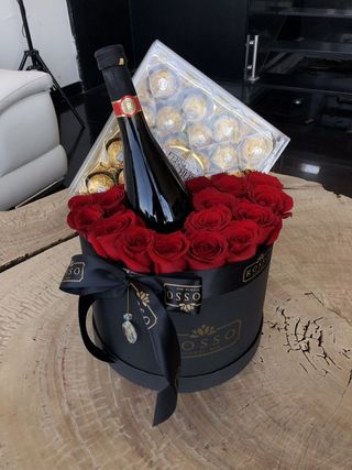 Red roses in a black box with wine and ferrero rocher
