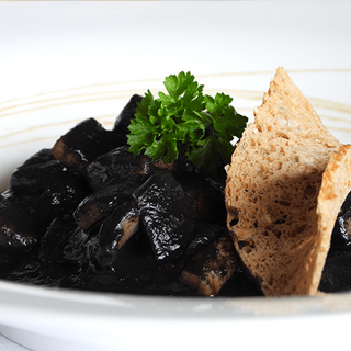 Txipirones en su tinta con pan de arroz