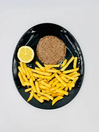 Hamburger di carne alla griglia con patatine fritte e limone