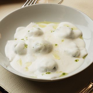 Raviolones hechos a mano de setas, ceps y mató con salsa parmesana y aceite de trufa