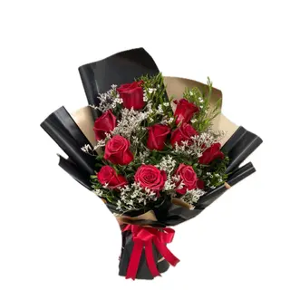 Ramo de rosas vermelhas sob comprido com papel preto