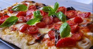 Pinsa con mozzarella fior di latte, rucola, pomodoro fresco acciughe olive