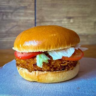 Crispy Chicken Burger Con lechuga, tomate, bacon y queso cheddar