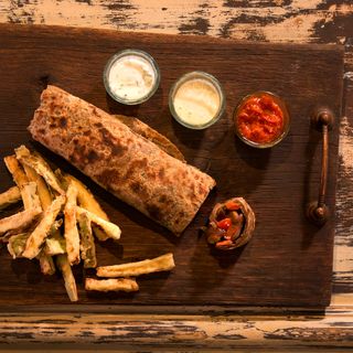 Авторски гирос - пълнозърнеста питка със свинско месо от порода иберико, конфи от червен лук, домати и три вида сосове – соева майонеза с трюфел, дзадзики с йогурт, водорасли и пикантна домашна лютеница