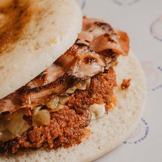 Mollete de sobrasada ibérica, baicon ahumado, cebolla caramelizada y queso de cabra