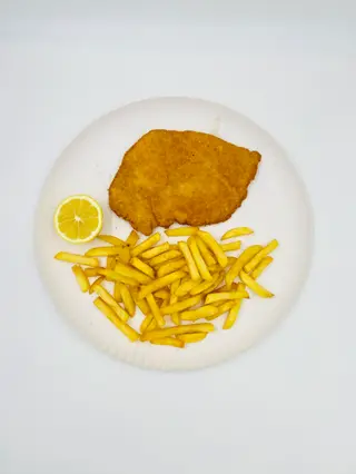 Cotoletta di pollo con patatine fritte e limone