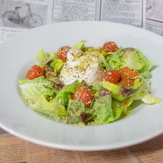 Ensalada burrata con tres tipos de tomate y pistacho