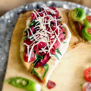 Pinsa con fiordilatte, zucchine, pomodoro fresco, bresaola e grana