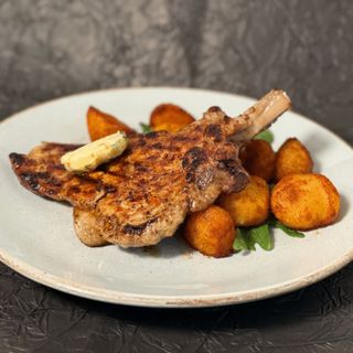 Kotlet schabowy z kością i masełkiem ziołowym z grilla