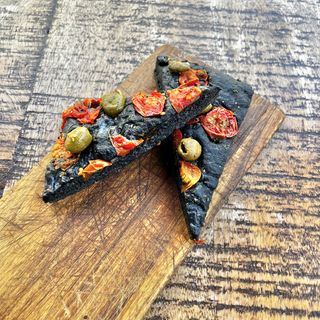 Focaccia de carbón vegetal y tomates cherry (porción)