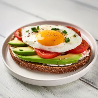 Tostada queso de untar, aguacate, tomate y huevo