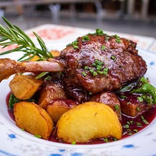 Confit de pato con patatas y salsa de frutos rojos