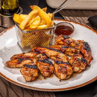 Aripioare arse pe jar cu sos bbq si cartofi prajiti