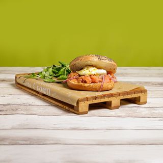 Salmone egg benedict bagel servito con valeriana e crema balsamica