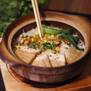 Riso in casseruola di terracotta con verdure, tofu e funghi
