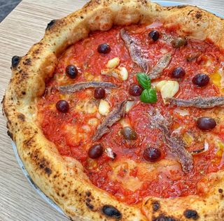 Pizza puttanesca alici aglio olive nere e origano 