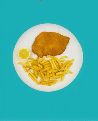 Cotoletta di pollo con patatine fritte e limone