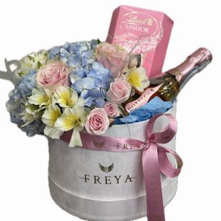 Cutie medie cu flori albastre si roz, spumant si ciocolata