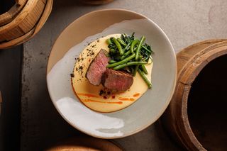 Яловичі медальйони в сирному соусі зі стручковою квасолею, бебі - шпинатом та часниковим маслом (160/100/70 г)